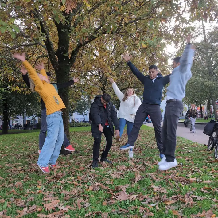 Fidelity Investments employees jumping for a team photo challenge during their digital treasure hunt in Galway City.