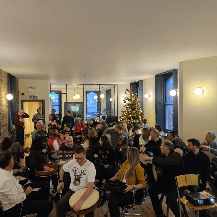 Group talking around the room with instruments ion their lap