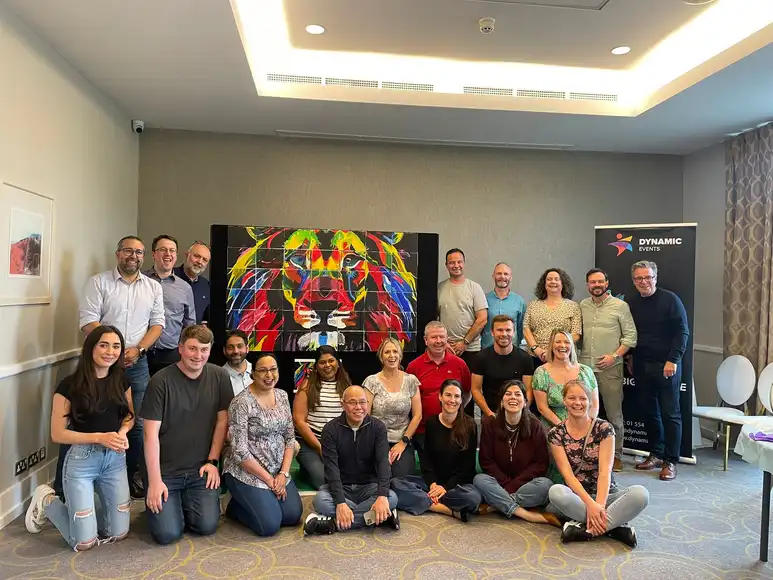 Office team collaborating on a creative indoor team building paint activity