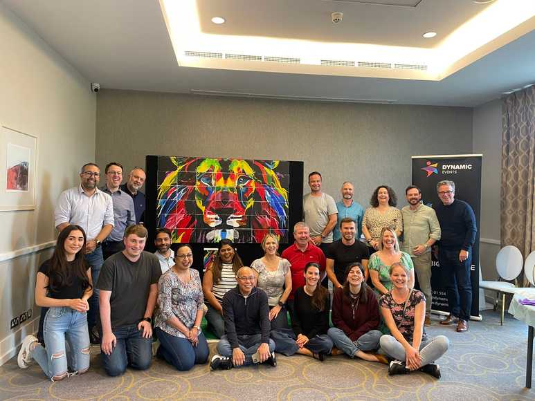 Office team collaborating on a creative indoor team building paint activity