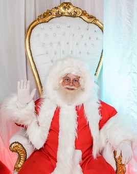 Santa Claus greeting attendees from his throne during a christmas team building activity designed for corporate teams and employee engagement.