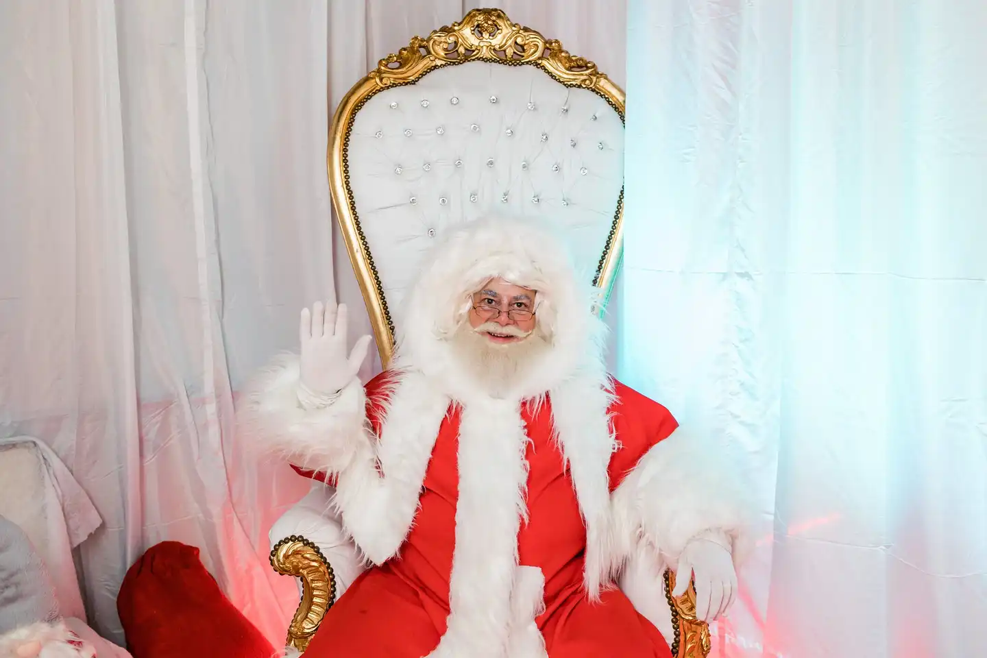 Santa Claus greeting attendees from his throne during a christmas team building activity designed for corporate teams and employee engagement.