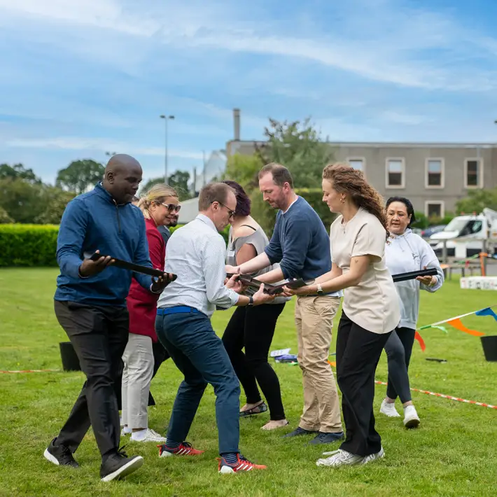 Corporate team working together to complete a pipe coordination challenge during The Challenger team building activity in Ireland