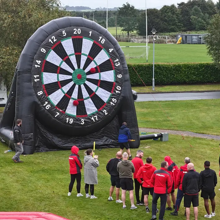 Hilti team playing inflatable darts challenge during outdoor team building event at The Johnstown Estate