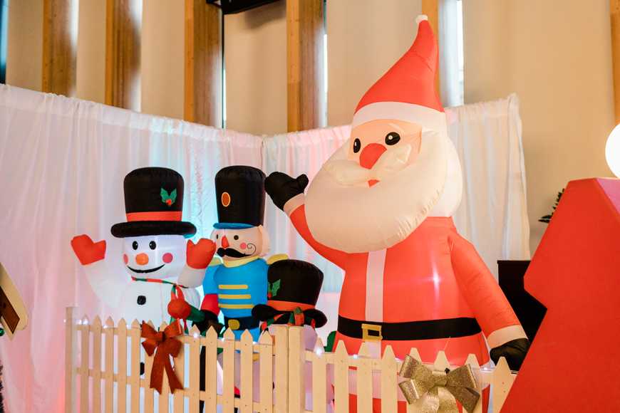 Inflatable Santa and snowmen at a corporate Christmas team building event, creating a festive grotto backdrop for staff and family celebrations.