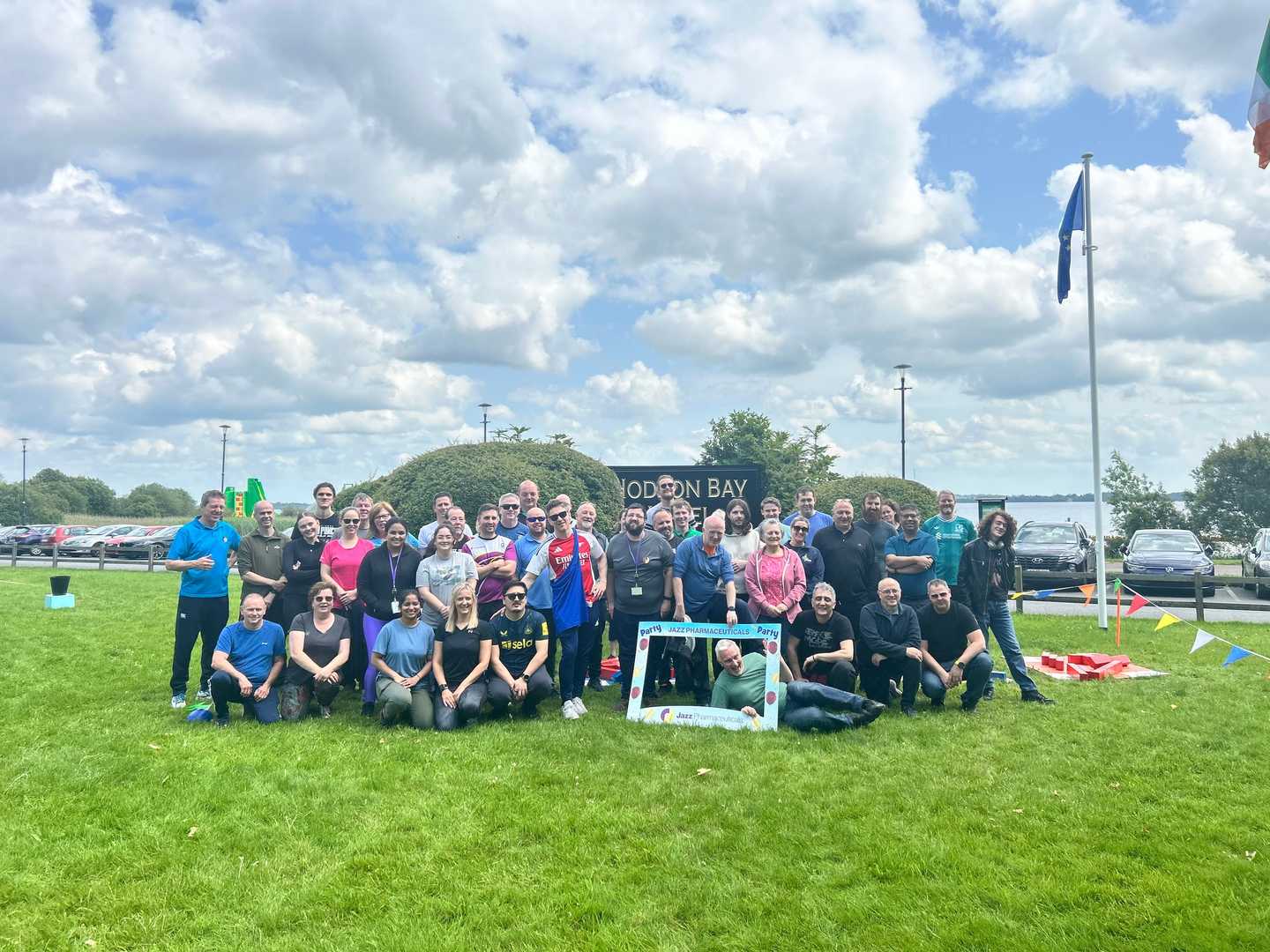 Full team group photo with participants smiling and posing together at the end of the summer team-building day.