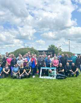 Full team group photo with participants smiling and posing together at the end of the summer team-building day.