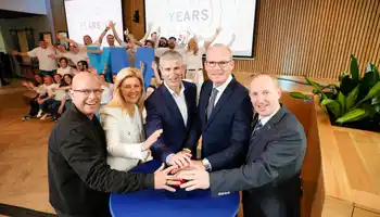 Corporate offsite event with Irish business leaders celebrating 10 year anniversary surrounded by team members at a modern venue in Ireland