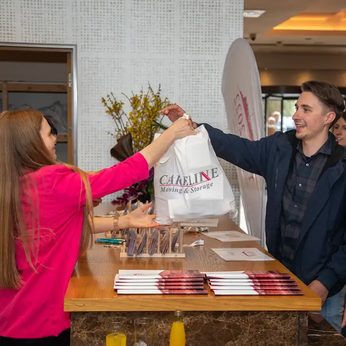 Attendee collecting welcome pack at company away day registration desk