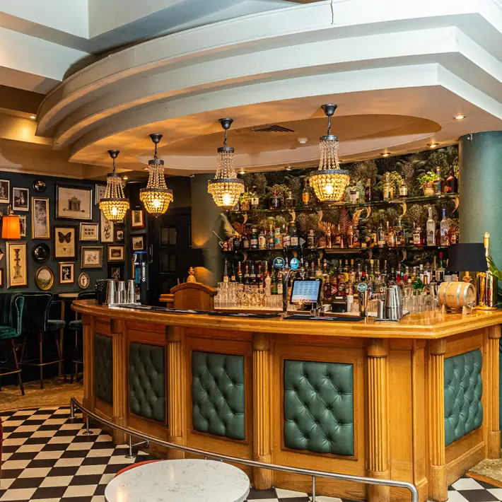Cocktail bar at 101 Limerick featuring a wooden bar, chandeliers and classic interior décor.