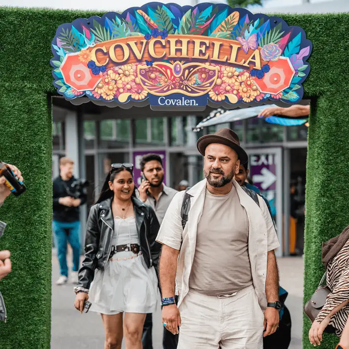 Staff arriving through a branded archway entrance at outdoor summer event