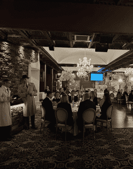 People looking at the actors who are acting out the murder mystery