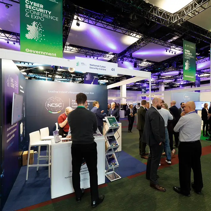 Wide view of the NCSC Cyber Expo exhibition floor at The Convention Centre Dublin, showing cybersecurity stands, event signage and delegates networking.