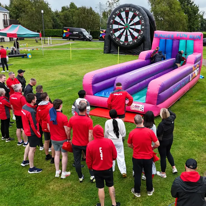 Hilti employees competing on inflatable bungee fun run during Team Olympics activity at summer party