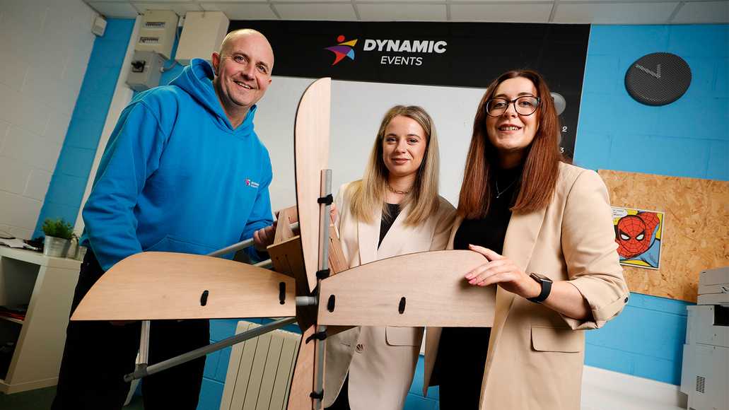 Corporate team building in Laois with Dynamic Events, employees collaborating to build a wooden wind farm model as part of a sustainable CSR activity.