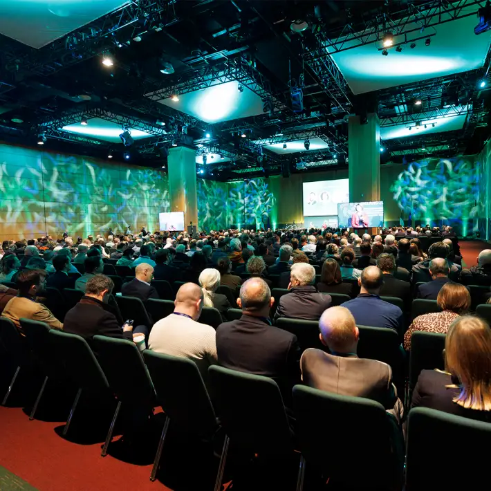 Large conference audience seated in an auditorium with professional stage lighting and presentation screens at the Cyber Security Conference and Expo