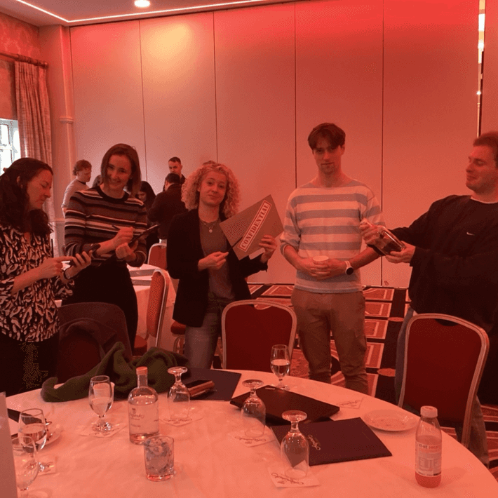 Team members collaborating on clues during the Murder Mystery Team Building game.