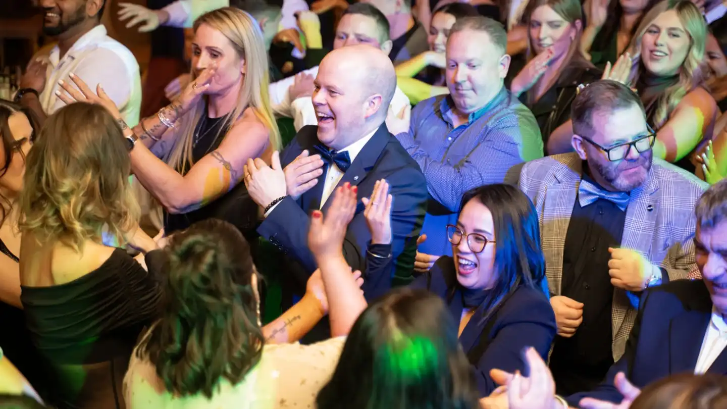 happy people dancing during disco bingo team building event at christmas party