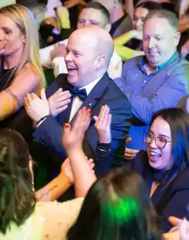 happy people dancing during disco bingo team building event at christmas party