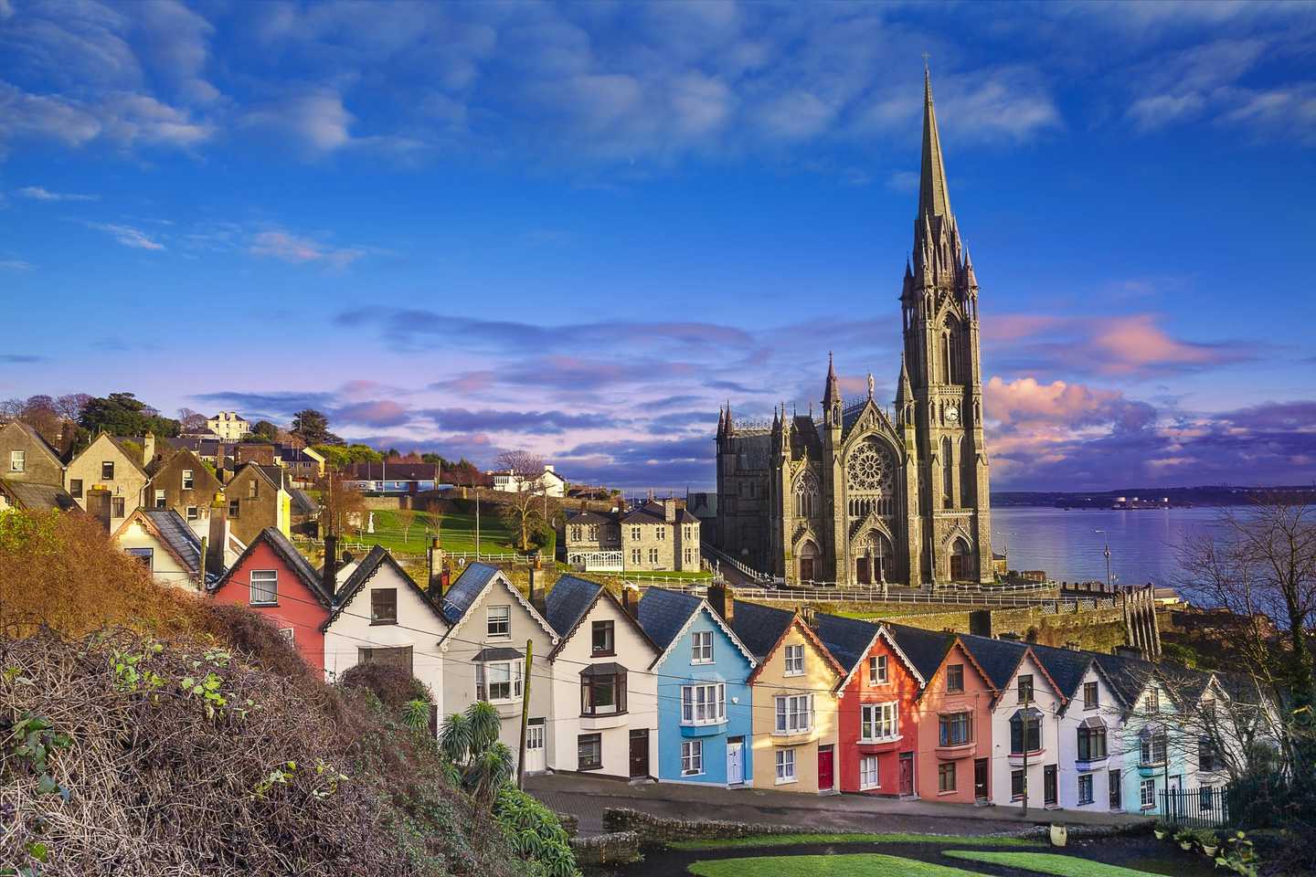 Iconic coloured houses on a hill down to the sea with a big church in the background and blue skies | Team Training