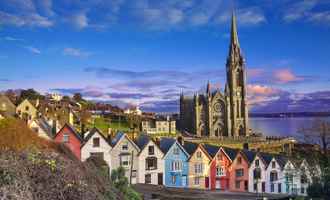 Iconic coloured houses on a hill down to the sea with a big church in the background and blue skies | Team Training