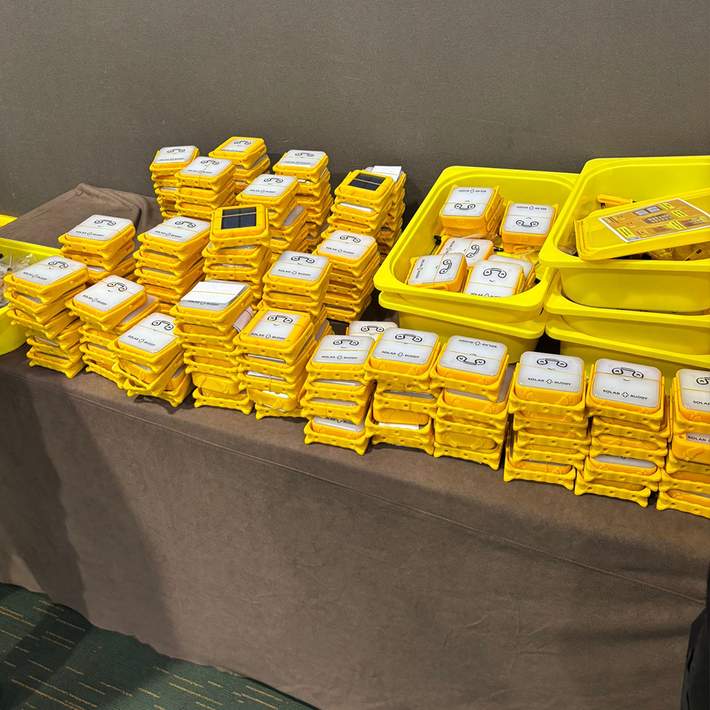 Stacks of completed SolarBuddy lights, ready to be distributed to communities in need, representing the event's real-world impact.