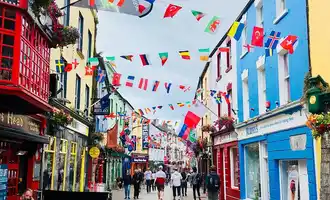 Quay Street, Galway City decorated with flags and colourful buildings | Team Traiing Galway