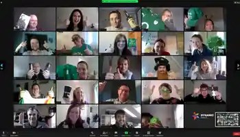 A vibrant virtual St. Patrick’s Day event featuring a multinational corporate team on a video call. Participants are dressed in festive green attire, holding Irish-themed props, and giving thumbs-up, creating an engaging and celebratory atmosphere. The Dynamic Events logo is visible, reinforcing the corporate virtual team-building theme.