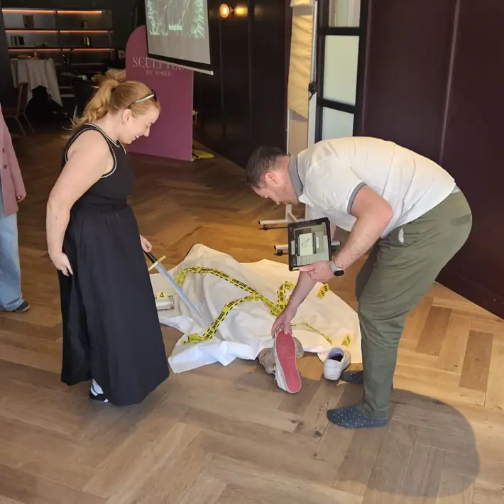 Corporate team taking part in the Manor House Murder team building activity in Ireland, analysing a staged crime scene with iPads and evidence markers during an interactive indoor murder mystery event.