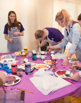 Corporate team painting activity in Ireland with colleagues collaborating and creating artwork together during a creative team building event.