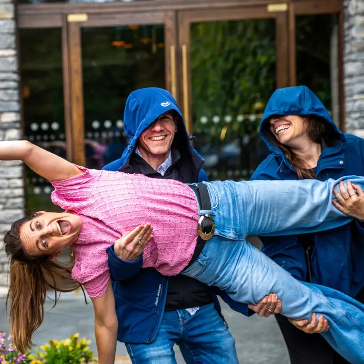 two people holding up a woman sideways for a photo op 