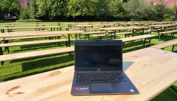 Picnic benches set up for a corporate hospitality event in a green park setting with surrounding Georgian buildings.
