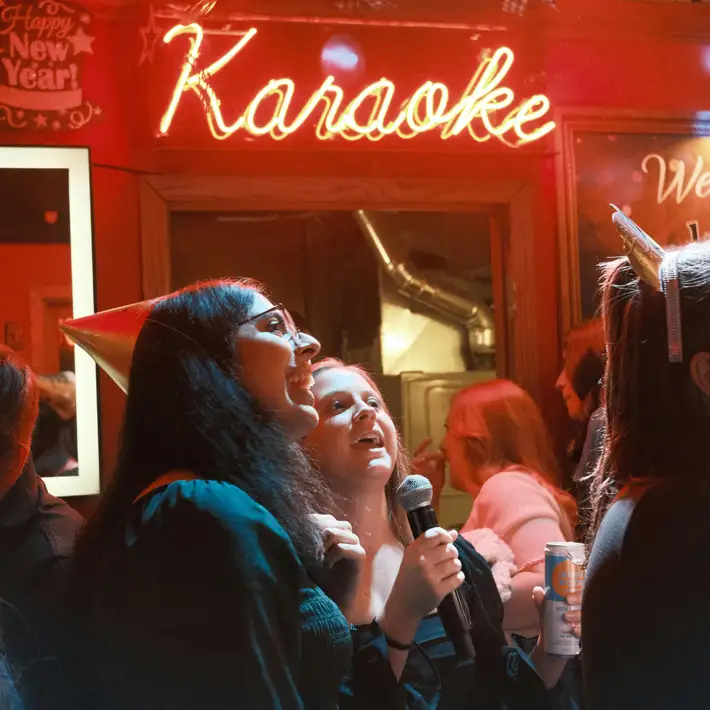 Colleagues cheering during group karaoke performance