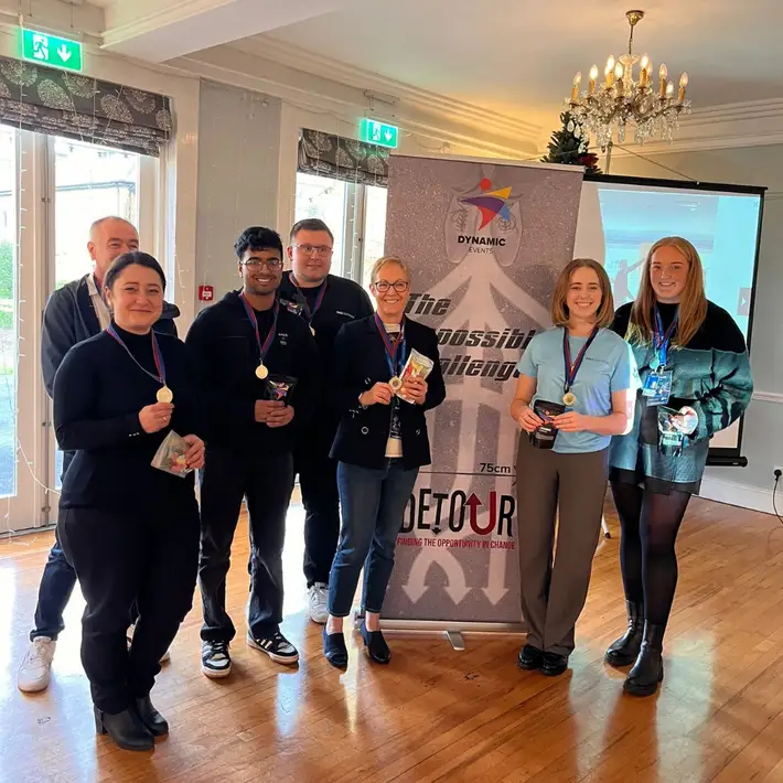 Detour winners infromt of banner