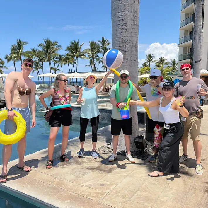 Corporate team taking part in digital treasure hunt activity by pool at Maui resort