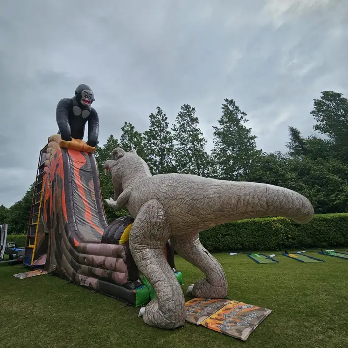 Children playing on inflatable gorilla and pool mini golf ball games at the outdoor games zone
