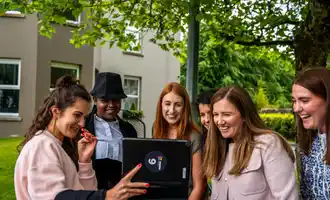 Corporate team using a tablet outdoors during a digital scavenger hunt activity in Ireland