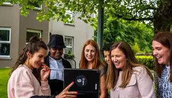 Corporate team using a tablet outdoors during a digital scavenger hunt activity in Ireland