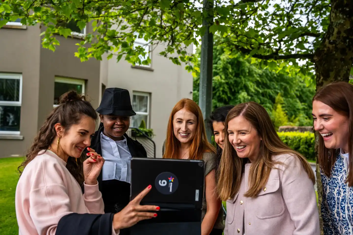 Corporate team using a tablet outdoors during a digital scavenger hunt activity in Ireland