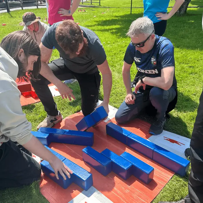 A small group focused on assembling colourful geometric shapes as part of a problem-solving activity.