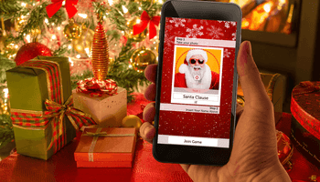 christmas crackers game on phone with christmas presents and tree in the background
