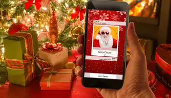 christmas crackers game on phone with christmas presents and tree in the background