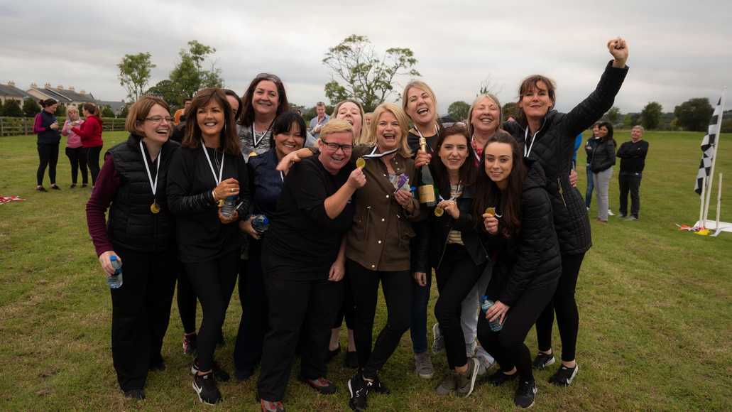 Corporate team celebrating together after completing outdoor team building challenge in Shannon