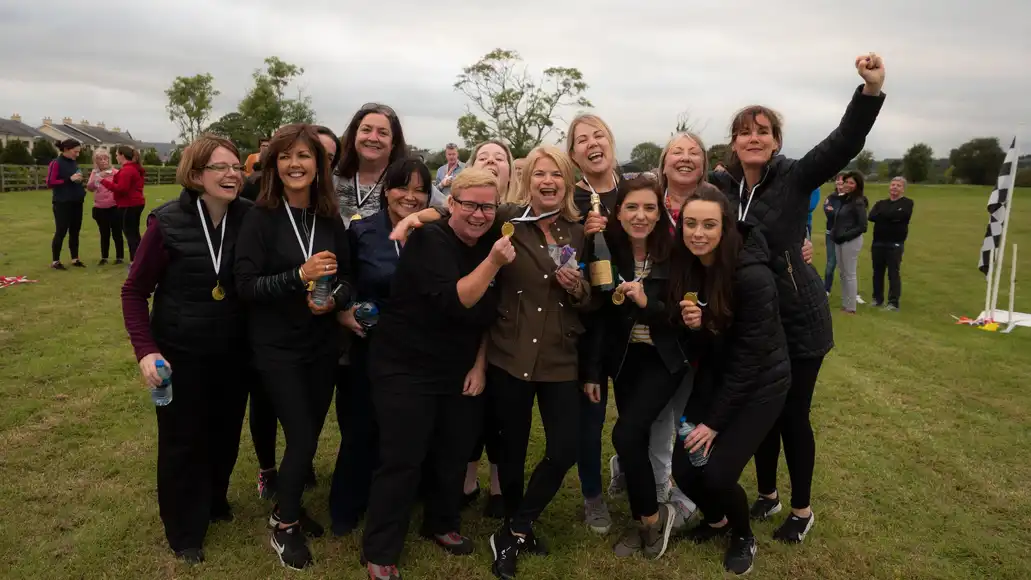 Corporate team celebrating together after completing outdoor team building challenge in Shannon