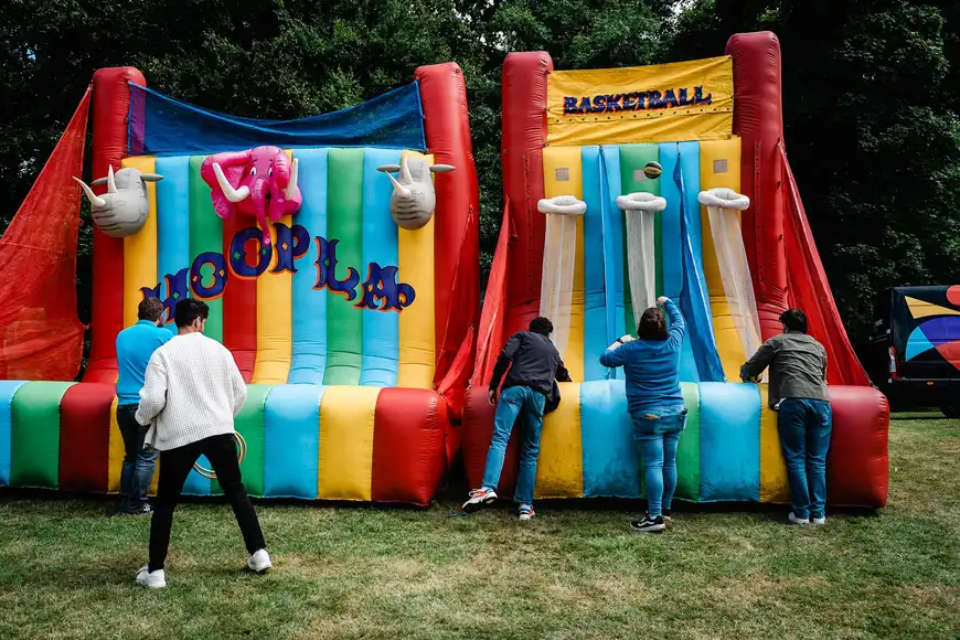 Corporate team building day with employees playing inflatable hoopla and basketball games outdoors in Sligo, Ireland.