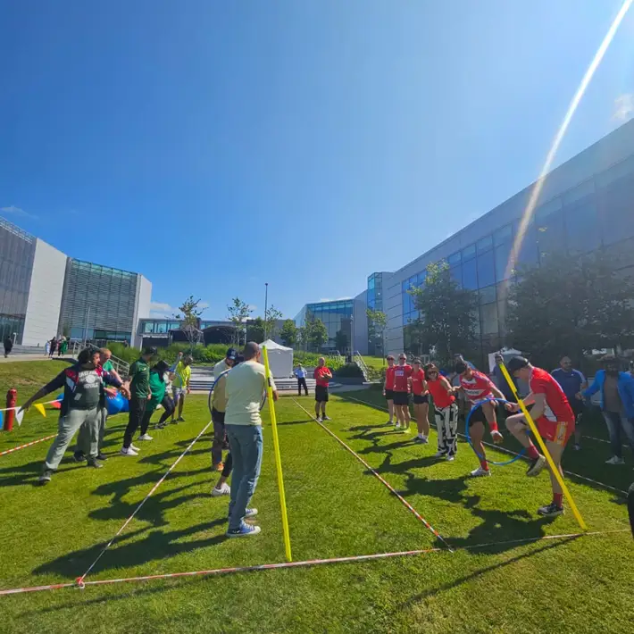 Apple staff taking part in elephant chain hoop and working together 