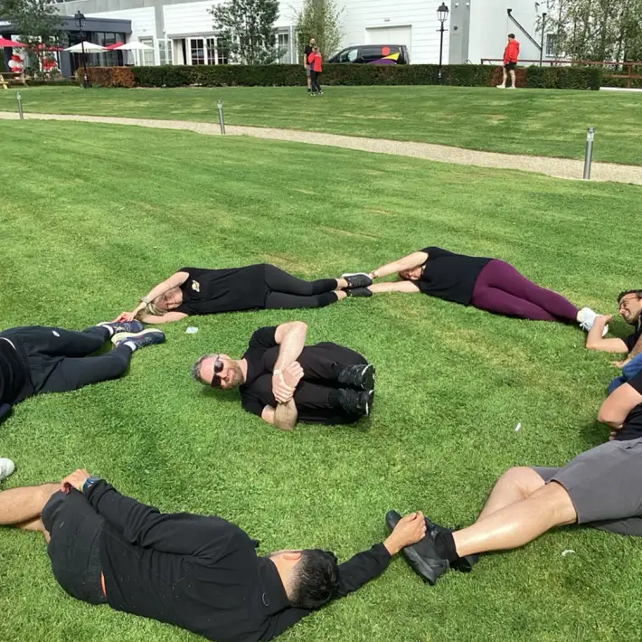 Corporate team taking part in the Space Survival team building activity, creating a Jupiter shape together on the grass during a Dynamic Events outdoor treasure hunt in Ireland.