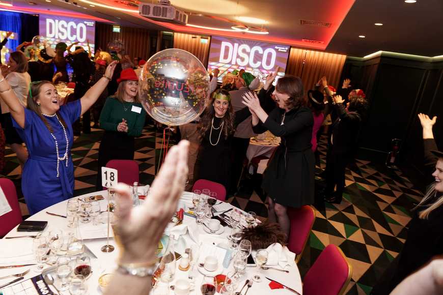 Colleagues dancing and cheering during a Disco Bingo fun corporate team building event in Dublin.