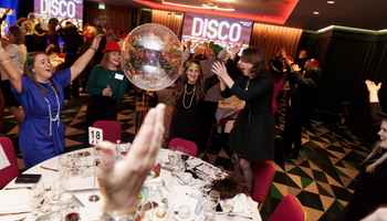 Corporate team enjoying Disco Bingo at a lively team building event with music, party games, and dancing at a hotel venue in Ireland