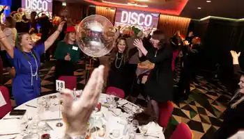Corporate team enjoying Disco Bingo at a lively team building event with music, party games, and dancing at a hotel venue in Ireland